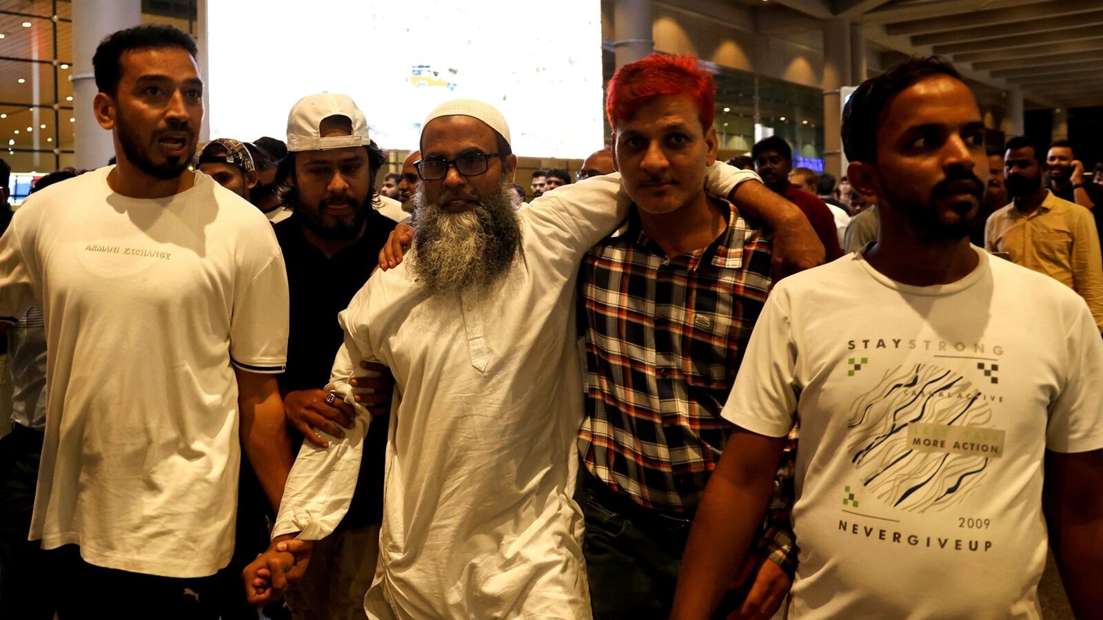 Shaikh Mohammed Ali Alam Shaikh, centre, one of the persons acquitted by the Bombay High Court in the 7/11 Mumbai train blasts case on Monday, being received by family and friends upon his arrival at the airport, in Mumbai