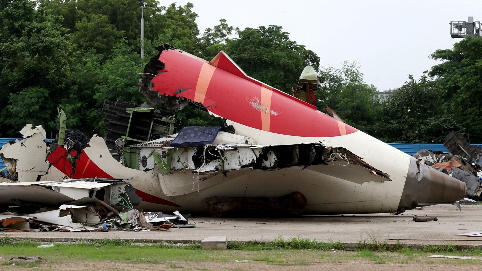 Wreckage of the Air India Boeing 787-8 Dreamliner plane sits on the open ground, outside Sardar Vallabhbhai Patel International Airport