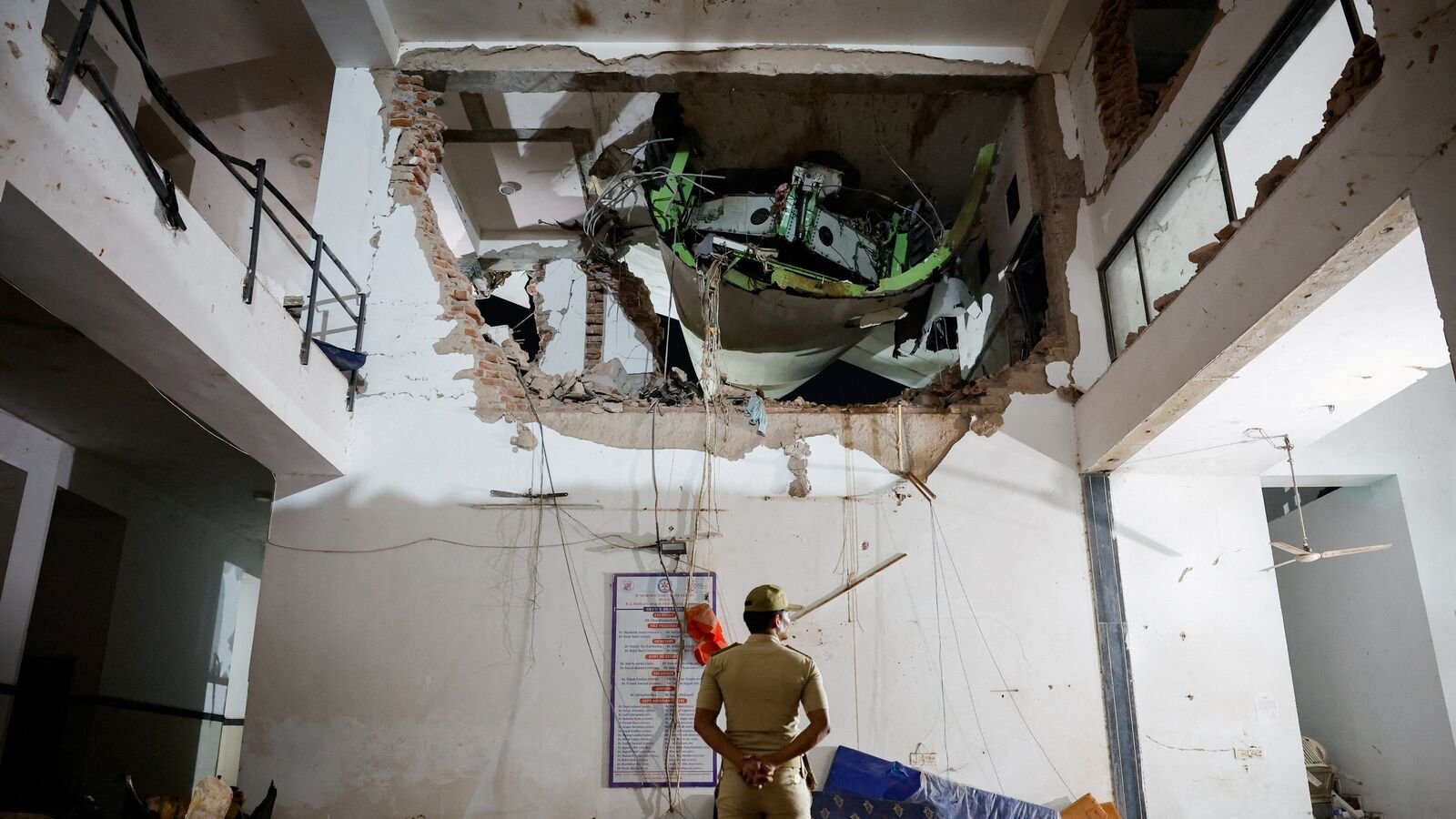 FILE PHOTO: A police officer stands in front of the wreckage of an Air India aircraft, bound for London's Gatwick Airport, which crashed during take-off from an airport in Ahmedabad, India June 12, 2025. REUTERS/Adnan Abidi/File Photo