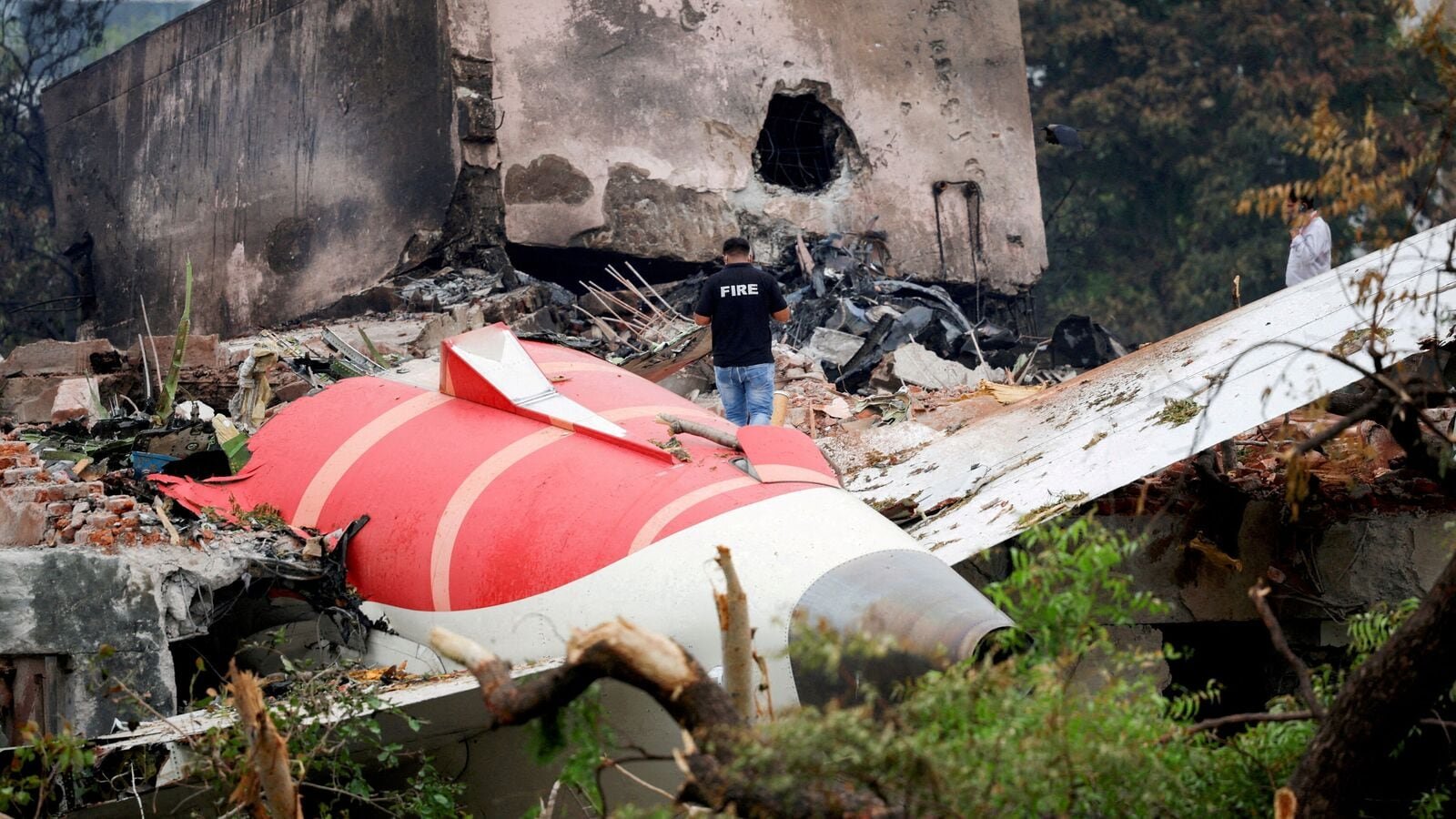 FILE PHOTO: A firefighter stands next to the crashed Air India Boeing 787-8 Dreamliner aircraft, in Ahmedabad, India, June 13, 2025. REUTERS/Adnan Abidi/File Photo/File Photo