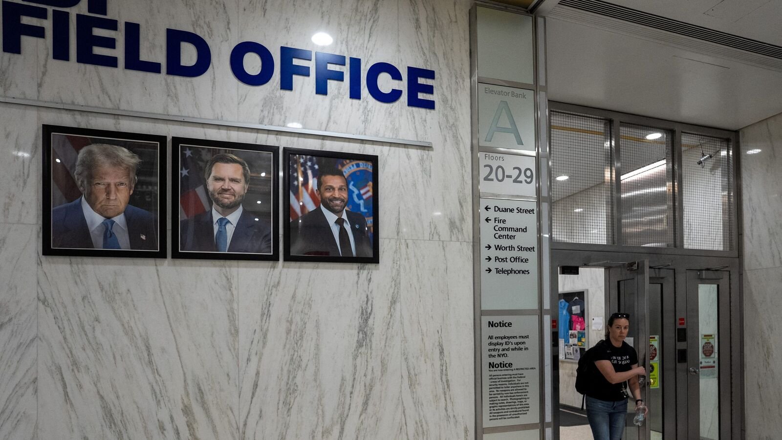 A person walks out of an FBI field office, near images of U.S. President Donald Trump, Vice President JD Vance and FBI Director Kash Patel, at a U.S. immigration court in Manhattan, in New York City, U.S., July 10, 2025. REUTERS/David 'Dee' Delgado