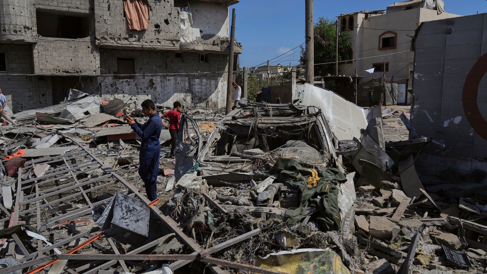 Palestinians inspect the wreckage of a gas station destroyed in an Israeli airstrike in Deir al-Balah, central Gaza Strip, Saturday, July 12, 2025.