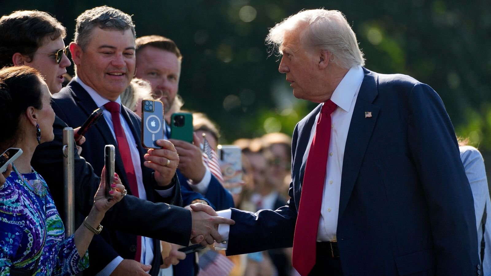A person shakes hands with US President Donald Trump, on the South Lawn at the White House in Washington, DC, US, July 25, 2025.