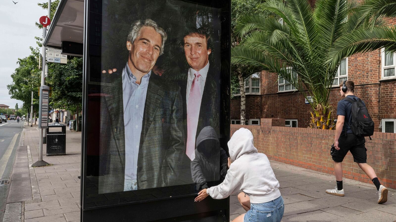 Activists put up a poster showing President Donald Trump and Jeffrey Epstein near the U.S. Embassy in London, Thursday, July 17, 2025.(AP Photo/Thomas Krych)