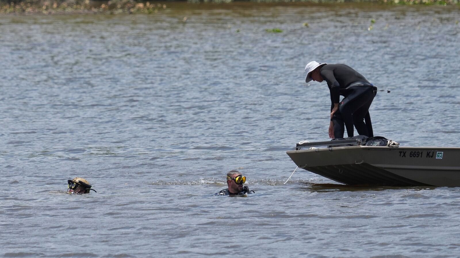 Divers search along the Guadalupe River after a flash flood swept through the area, Saturday, July 12, 2025, in Kerrville, Texas.