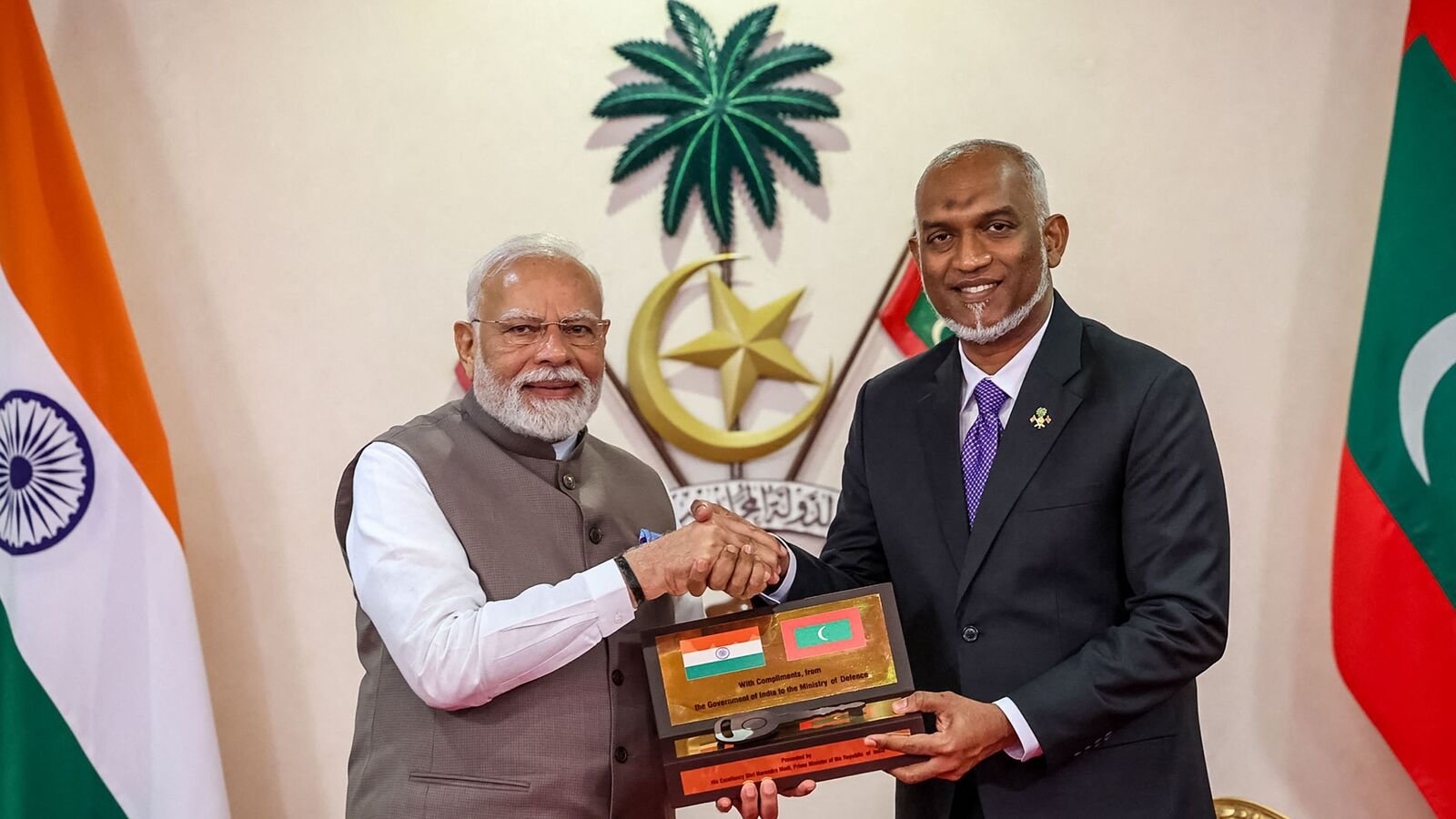 TOPSHOT - This handout photograph taken and released by the Indian Press Information Bureau (PIB) on July 25, 2025 shows President of Maldives Mohamed Muizzu (R) and India's Prime Minister Narendra Modi posing ahead of exchanging a Memorandum of Understanding (MoU) in Male. India's Prime Minister Modi offered $565 million to the Maldives on July 25 to bolster its defence forces and infrastructure in the small, yet strategically located, neighbour. (Photo by Indian Press Information Bureau (PIB) / AFP)