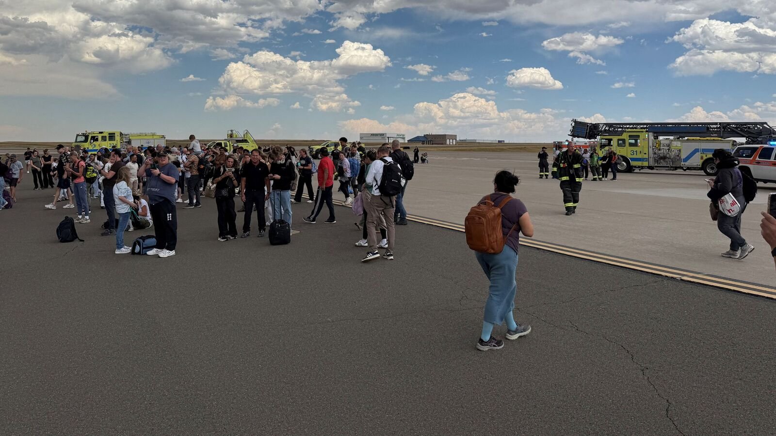 Passengers gather after evacuating an American Airlines plane that caught fire, at the Denver International Airport, Denver, Colorado, U.S. July 26, 2025, in this picture obtained from social media. @highlymigratoryfishing via Instagram/via REUTERS