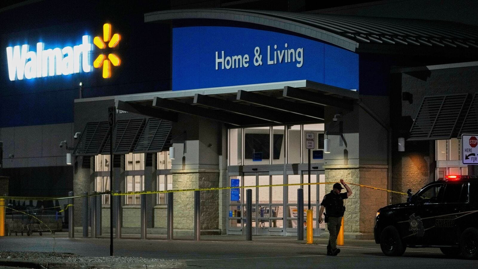Law enforcement officers cross caution tape outside a Walmart where 11 people were stabbed in a violent attack Saturday, July 26, 2025, in Traverse City, Mich (AP Photo/Ryan Sun)