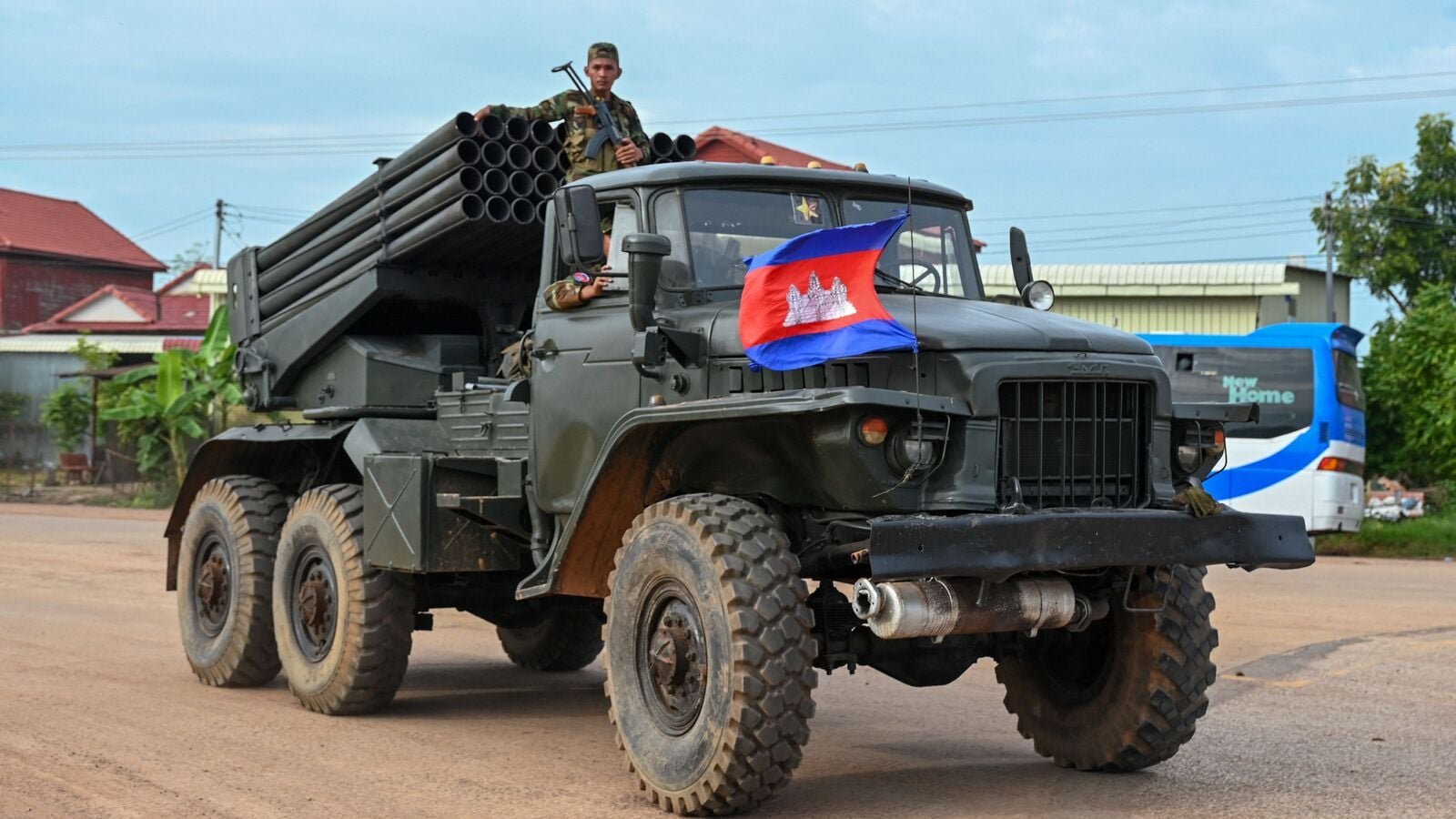A Cambodian soldier stands on a truck carrying a Russian-made BM-21 rocket launcher travelling along a street in Oddar Meanchey province on July 25, 2025.