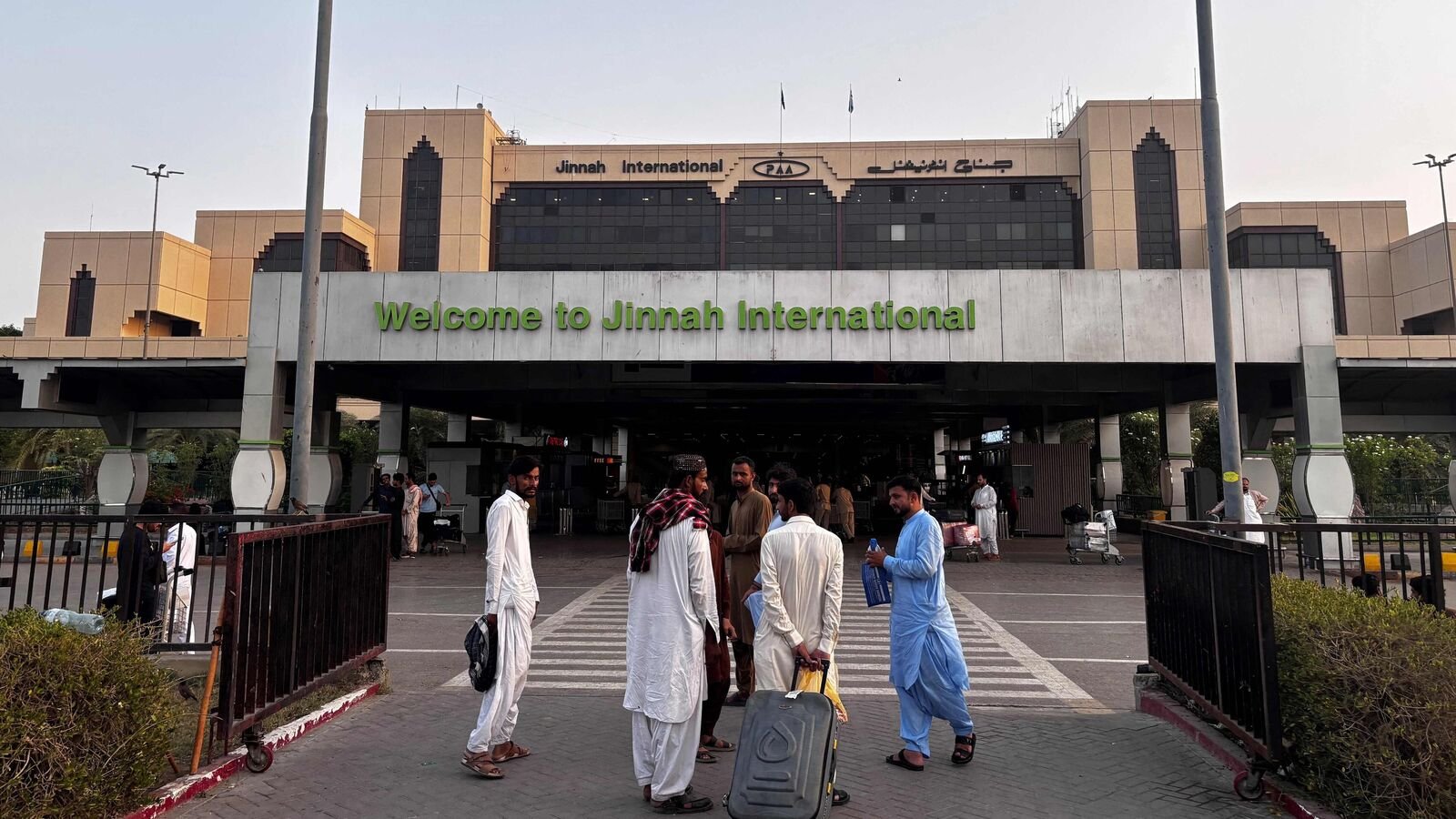 Passengers wait outside at Jinnah International airport. (Photo by Asif HASSAN / AFP) (File)