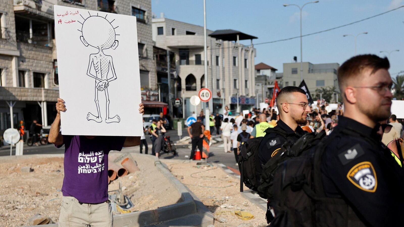 A man holds a poster during a protest calling on the government to end hunger in Gaza, in Sakhnin, Israel July 25, 2025  REUTERS/Ammar Awad