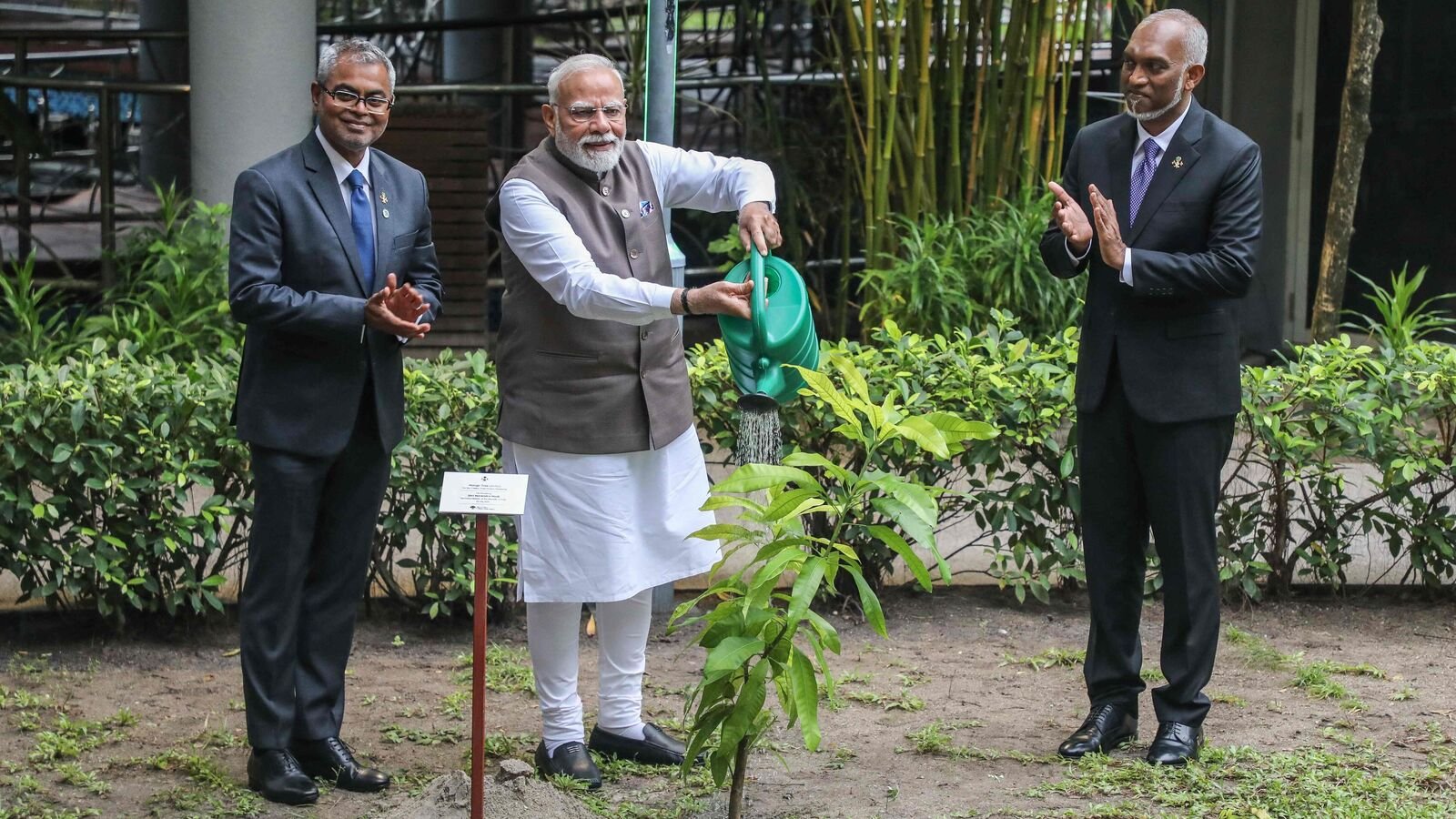 The President of Maldives Mohamed Muizzu reacts as India's Prime Minister Narendra Modi plants a tree sapling during his state visit in Male on July 25, 2025. (Photo by Mohamed Afrah / AFP)