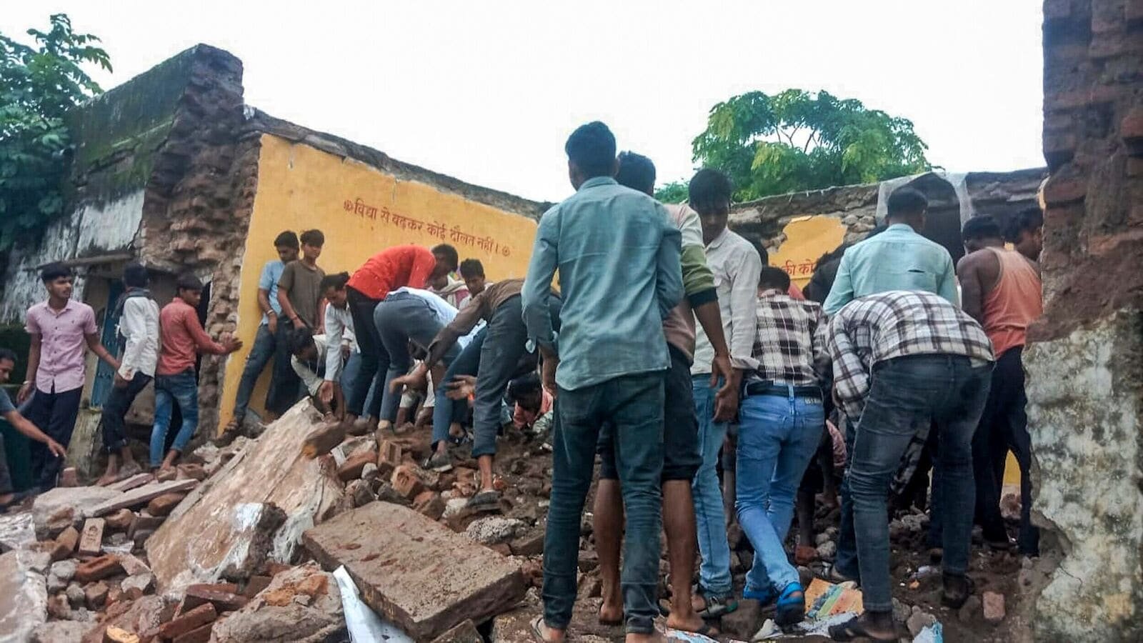 Locals carry out a rescue operation after a government school building collapsed in Rajasthan's Jhalawar district, on Friday, July 25, 2025.