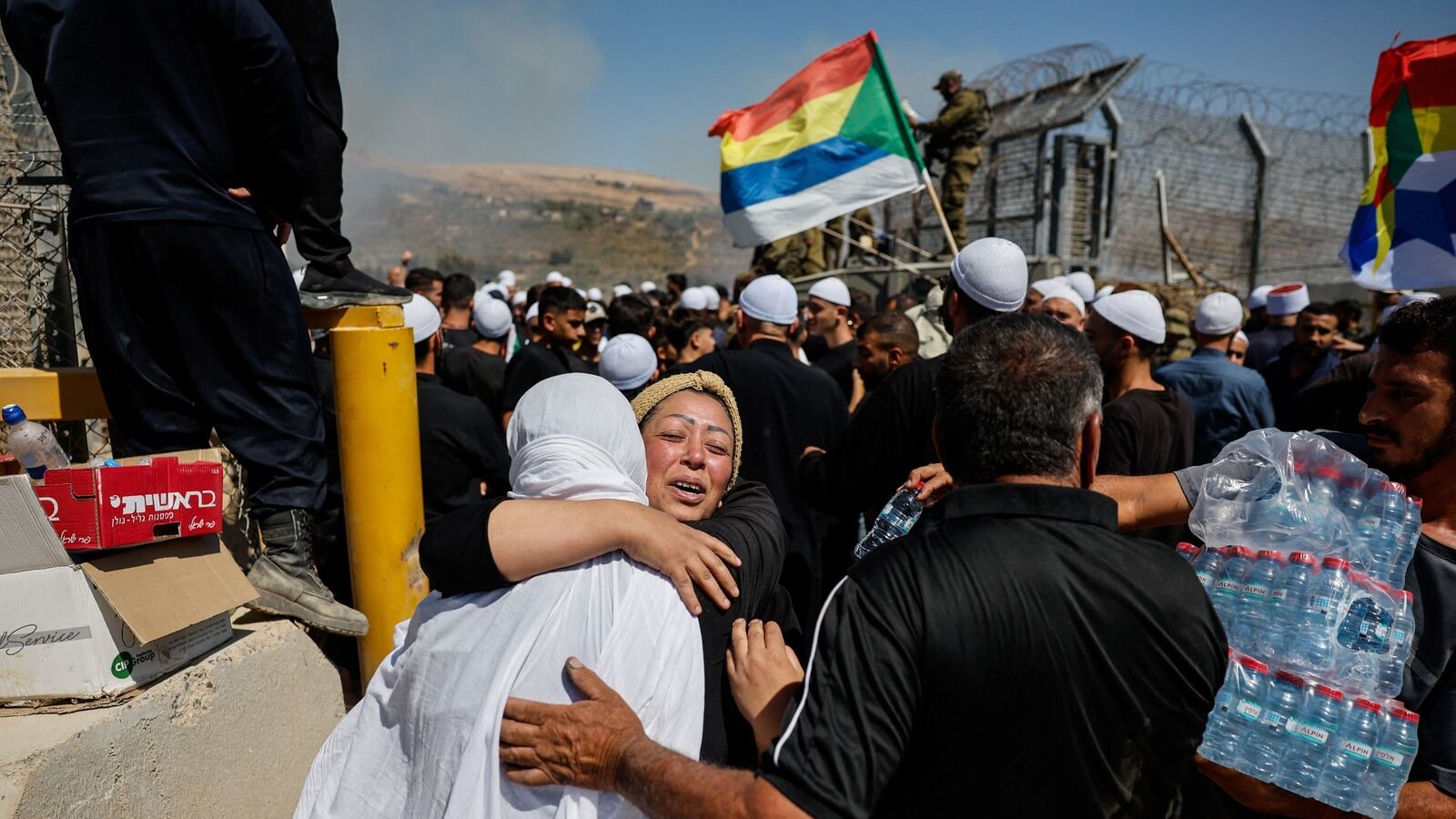 A Druze woman from Syria, meets her sister as she crosses to the Israeli side from the open border to check her family members, amid the ongoing conflict in the Druze areas in Syria, near the ceasefire line between the Israeli-occupied Golan Heights and Syria, July 16, 2025. REUTERS/Ammar Awad