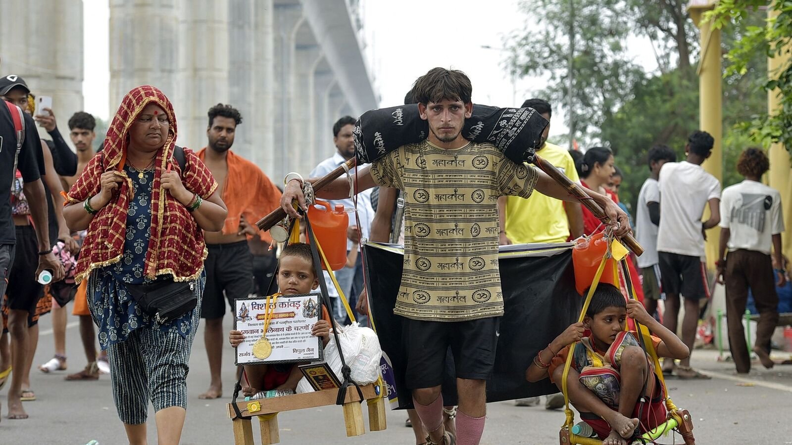Devendra Kumar, a resident of Delhi, carries the Kanwar from Haridwar along with his two nephews  during the Kanwar Yatra in Ghaziabad, India, on Monday. (Photo by Hindustan Times)