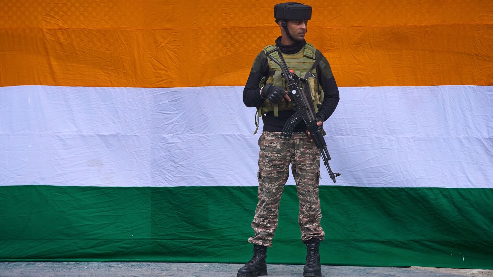 An Indian paramilitary soldier stands guard near the national flag on the eve of India's Independence Day in Srinagar, Indian controlled Kashmir, Thursday, Aug. 14, 2025. (AP Photo/ Dar Yasin )