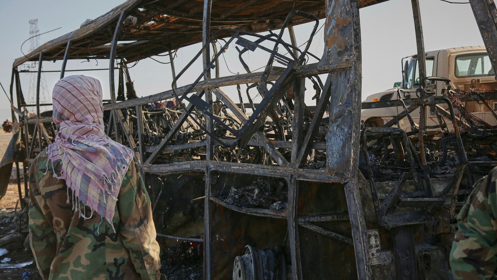 A man looks at a burned-out bus that collided with a truck and a motorbike Tuesday evening, causing a massive fire and killing at least 70 people, including children, most of them Afghans returning from Iran, in western Herat province, Afghanistan, Wednesday, Aug. 20, 2025.