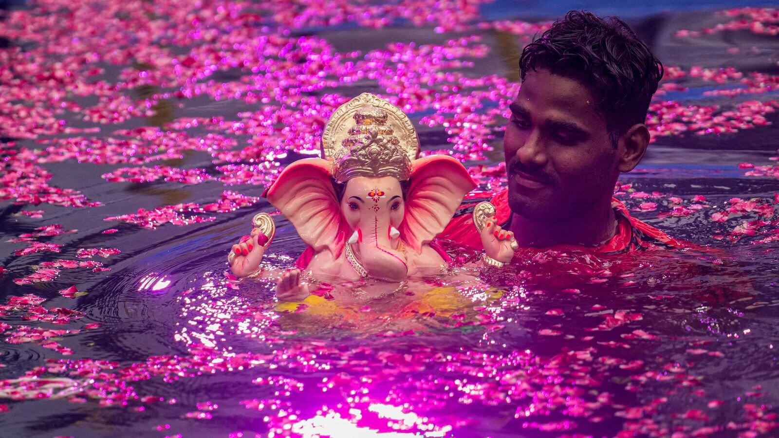 An idol of Lord Ganesha is immersed at an artificial pond during the one-and-a-half-day visarjan after Ganesha Chaturthi, in Mumbai, on Thursday.