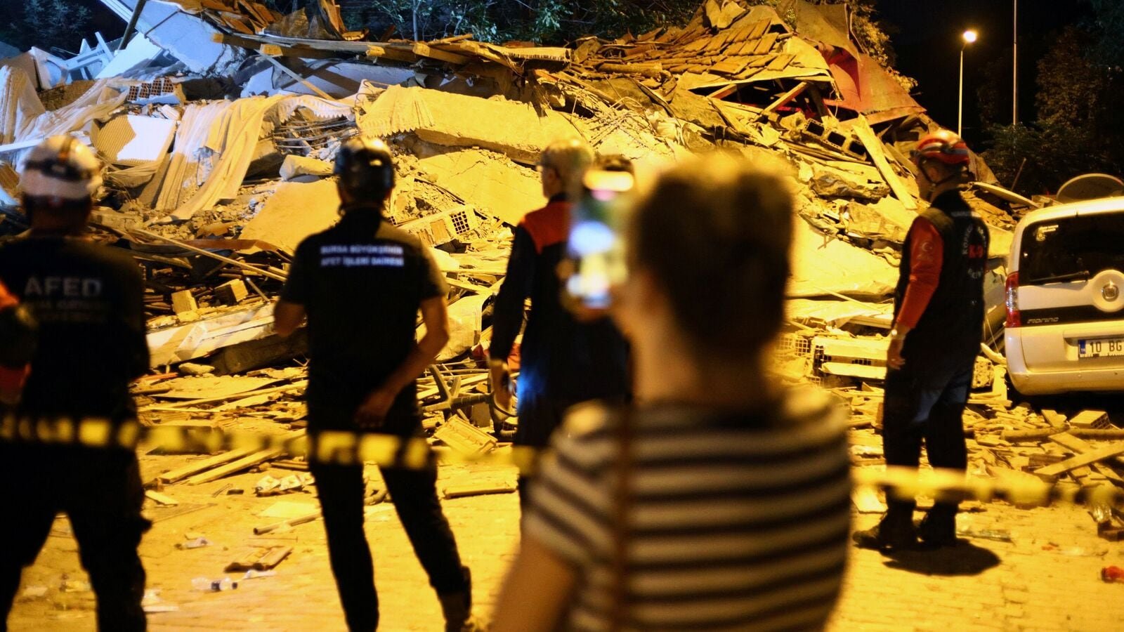 Rescuers stand at the site of a building that collapsed following an earthquake in Sindirgi, in the western Balikesir province, Turkey, August 11, 2025.