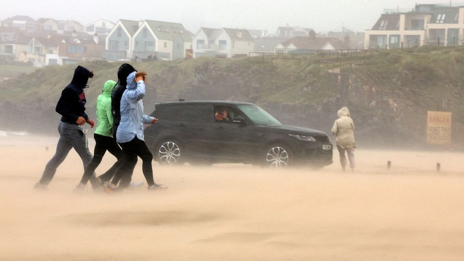 People run for cover during Storm Floris on the north coast of Northern Ireland, Portstewart, August 4, 2025. REUTERS/Cathal McNaughton      TPX IMAGES OF THE DAY