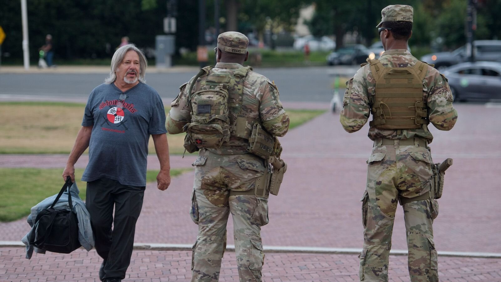 Armed members of the South Carolina National Guard talk with a man while positioned outside of Union Station in Washington, Sunday, Aug. 24, 2025. (AP Photo/Rod Lamkey, Jr.)