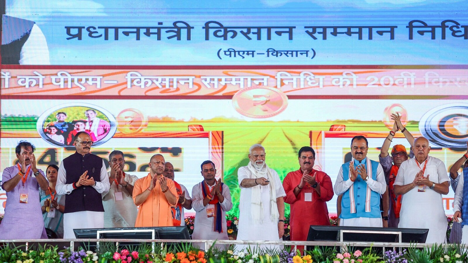 Varanasi, Aug 02 (ANI): Prime Minister Narendra Modi releases the 20th instalment of PM Kisan Samman Nidhi, transferring  <span class='webrupee'>₹</span>20,500 crores to 9.7 cr farmers, in Varanasi on Saturday. Uttar Pradesh CM Yogi Adityanath, State Deputy CMs Brajesh Pathak, Keshav Prasad Maurya and others also seen. (DPR PMO/ANI Photo)