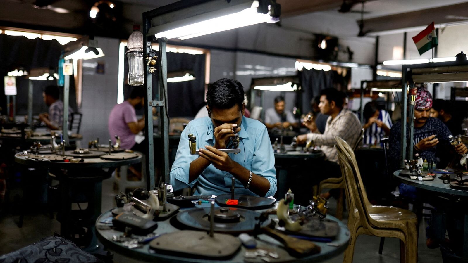 FILE PHOTO: Craftsmen work on diamonds inside a diamond processing unit in Surat, India, April 3, 2025. REUTERS/Anushree Fadnavis/File Photo