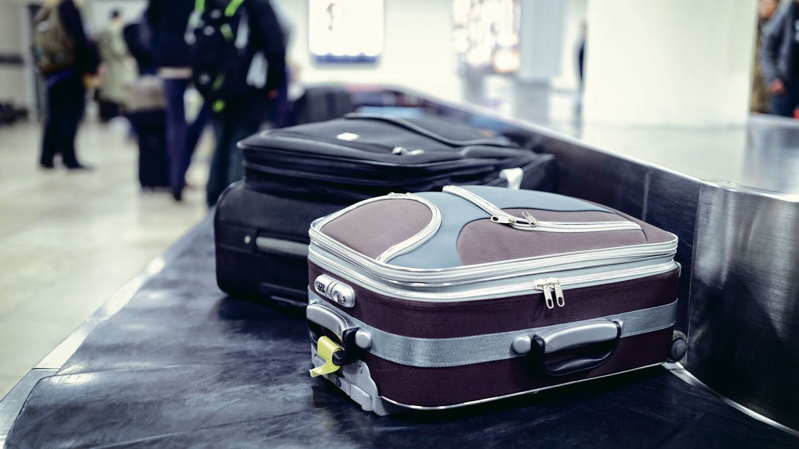 Suitcase on luggage conveyor belt in the baggage claim at airport.