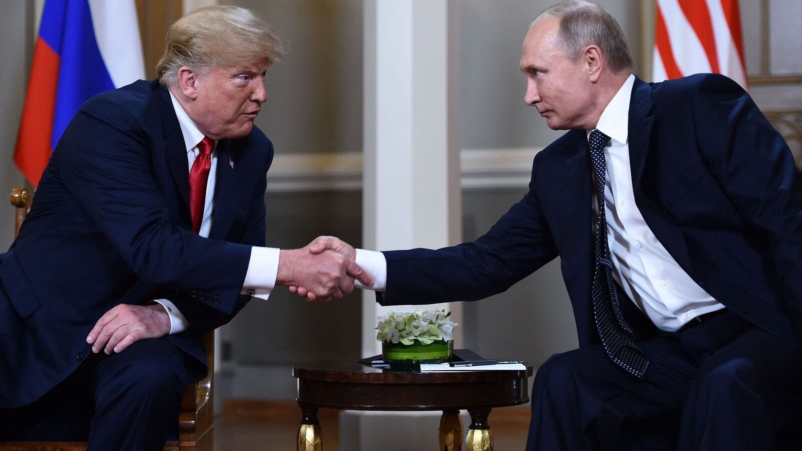 Russian President Vladimir Putin (R) and US President Donald Trump shake hands before a meeting in Helsinki, on July 16, 2018.