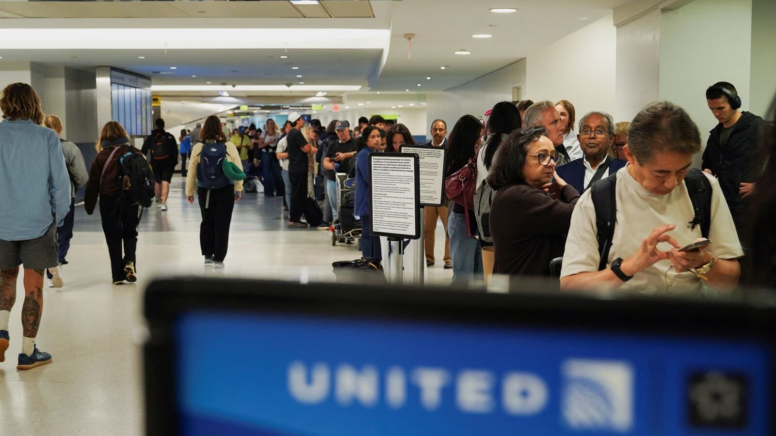 Travelers wait in line for their delayed luggage after United Airlines grounded flights due to a tech outage at Newark Liberty International Airport in Newark, New Jersey, U.S., August 6, 2025. REUTERS/Ryan Murphy