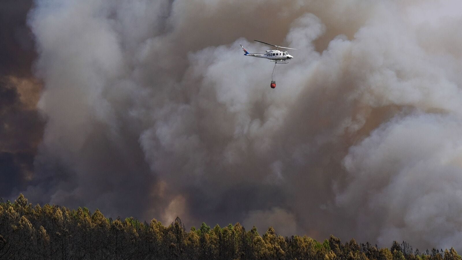 A firefighting helicopter works to extinguish a wildfire in Puercas de Aliste, near Zamora.