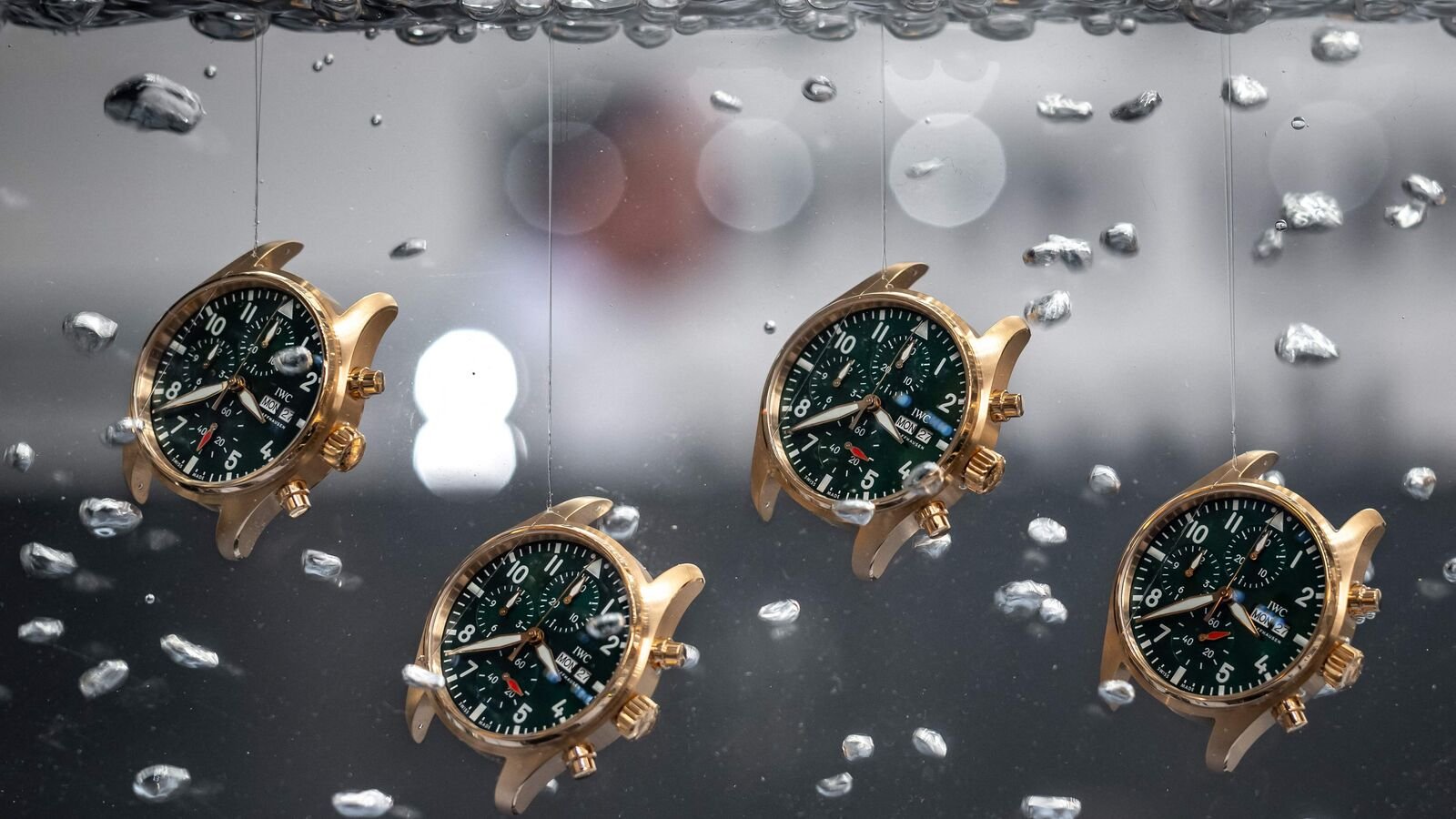 (FILES) Watches are seen in water at the booth of Swiss watch manufacturer IWC on the opening day of the luxury watch fair 'Watches and Wonders Geneva', in Geneva. (Photo by Fabrice COFFRINI / AFP)