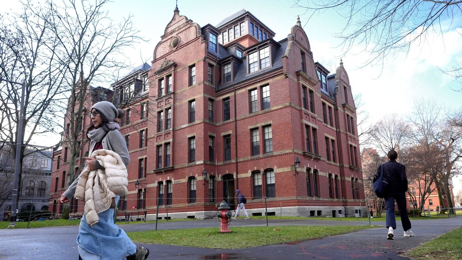 People walk between buildings on Harvard University campus, Dec. 17, 2024, in Cambridge, Mass. (AP Photo/Steven Senne, File)