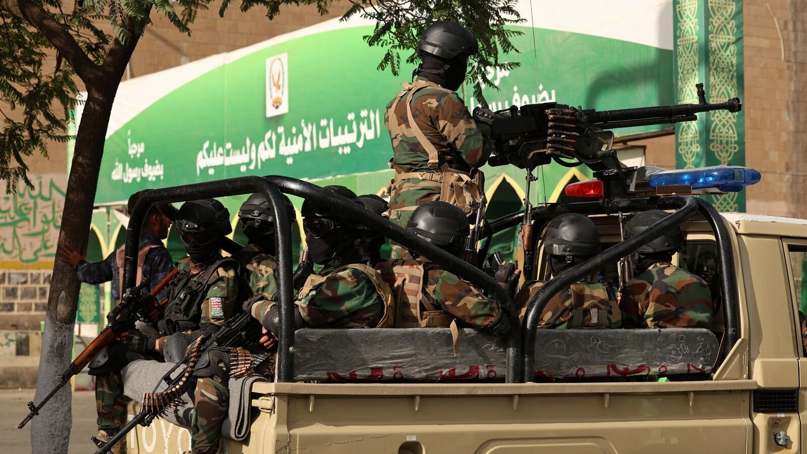 Houthi police troopers ride a patrol truck at the site where people mainly Houthi supporters, gather to mark the Prophet Muhammad's birthday in Yemen