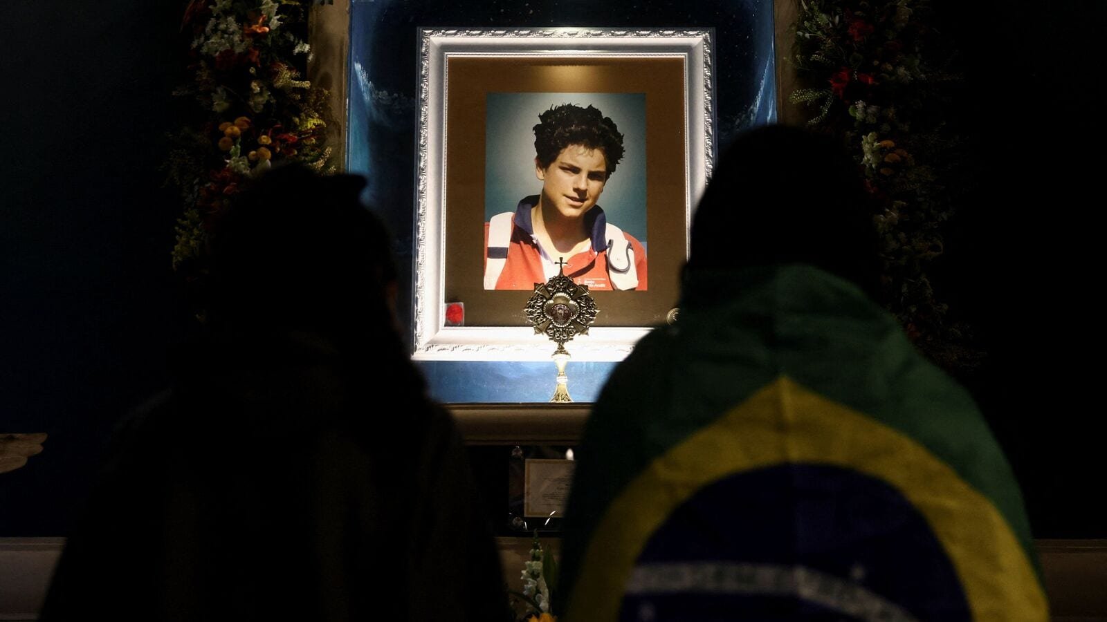 Worshippers stand before a relic of Carlo Acutis, a British-born Italian boy who became the first millennial Catholic saint, as they attend a Holy Mass celebrating his canonisation, at Parish Saint Carlo Acutis in Sao Paulo, Brazil September 7, 2025. REUTERS/Jean Carniel