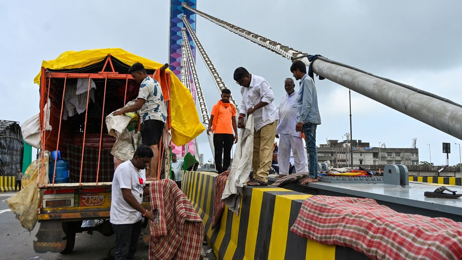 Maratha Morcha protesters take the rest on Reay Road cable bridge`s divider. (Photo by Raju Shinde/HT Photo)