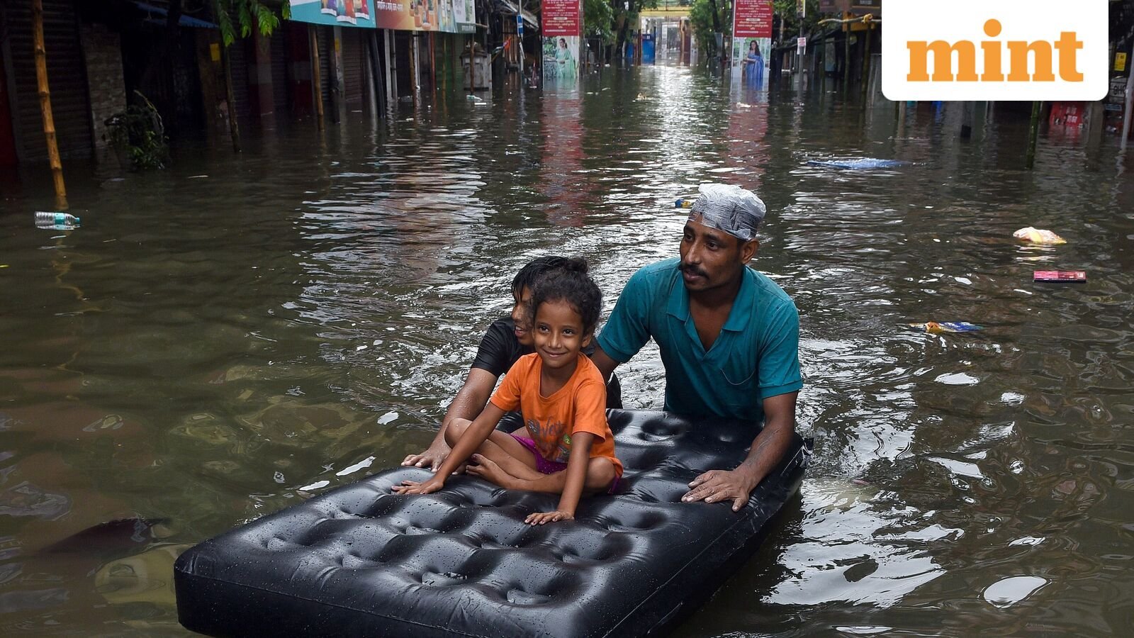 Kolkata, Sep 23 (ANI): Commuters wade through waterlogged streets of Kolkata on a mattress after heavy rainfall, in Kolkata, on Tuesday (ANI Photo).