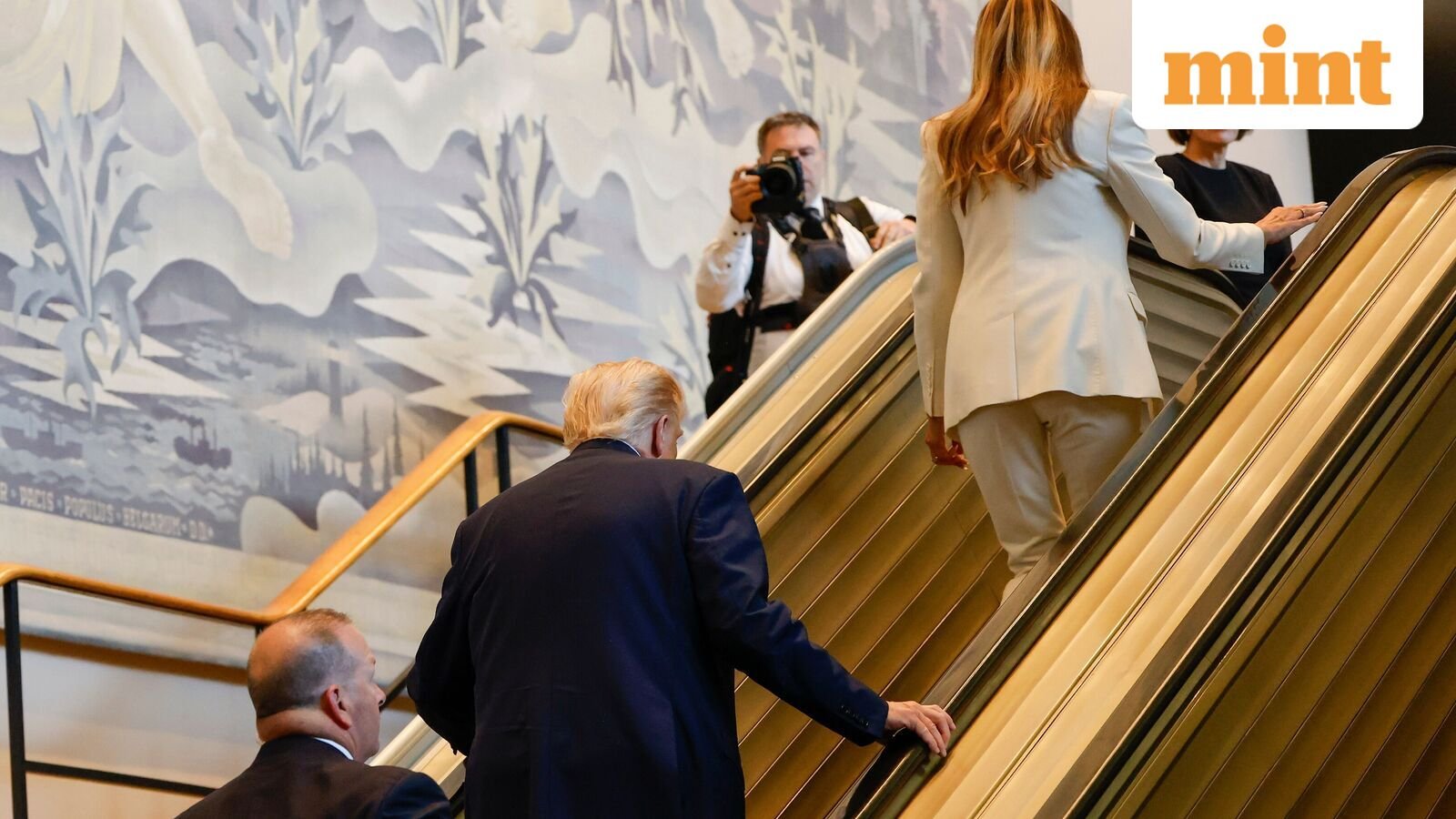 President Donald Trump, center, and First Lady Melania Trump, upper right, walk up the escalator after it stalled as he rode up to the General Assembly Hall, Tuesday, Sept. 23, 2025, at U.N. headquarters. (AP Photo/Stefan Jeremiah)