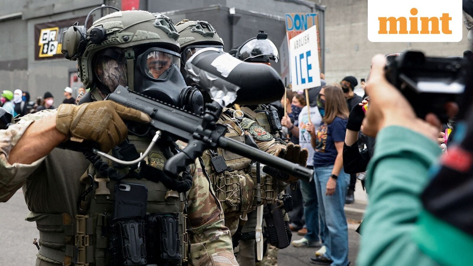 A law enforcement officer holds a gun in front of U.S. Immigration and Customs Enforcement (ICE) headquarters in south Portland, Oregon, U.S