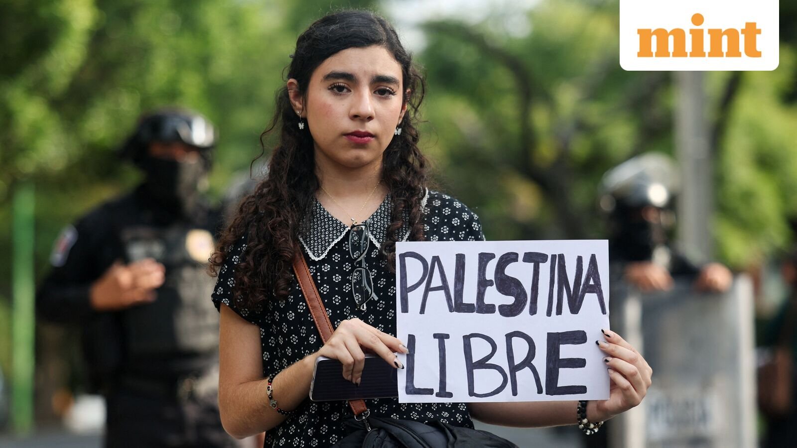 A woman shows a sign as demonstrators take part in a pro-Palestinian protest after Israel forces intercepted some of the vessels of the Global Sumud Flotilla aiming to reach Gaza and break Israel's naval blockade, outside of the Israeli embassy in Mexico City, Mexico October 3, 2025. REUTERS/Henry Romero