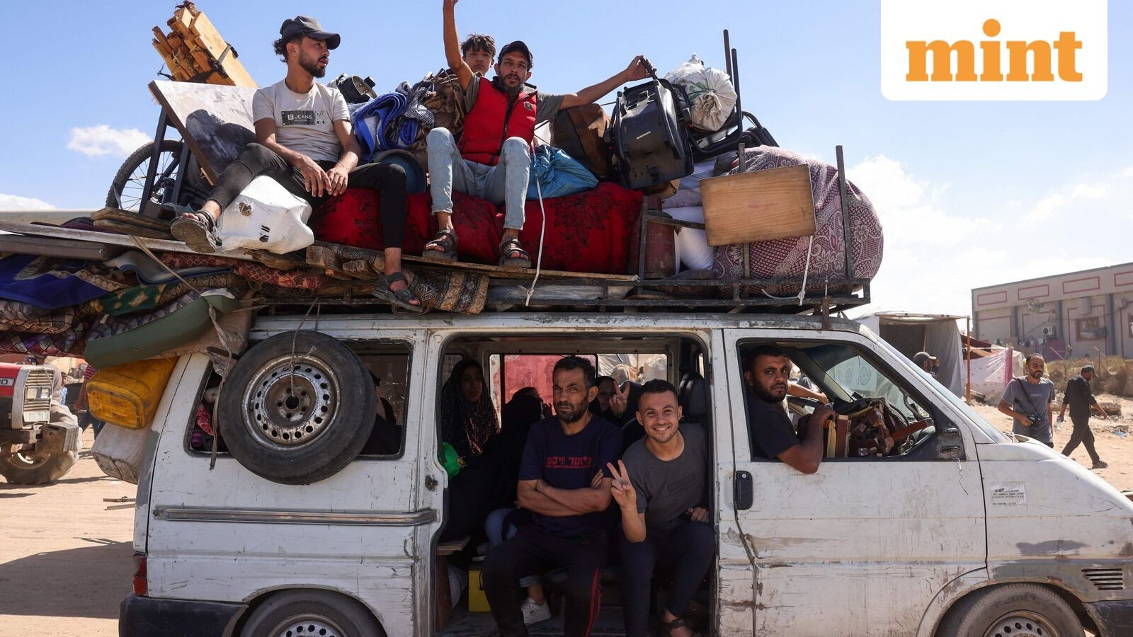 Palestinians carrying belongings arrive on a coastal path northwest of Nuseirat refugee camp as they are displaced southward from Wadi Gaza following an Israeli announcement of closing Al-Rashid road towards the north of the besieged Gaza Strip on October 1, 2025. (Photo by Bashar TALEB / AFP)