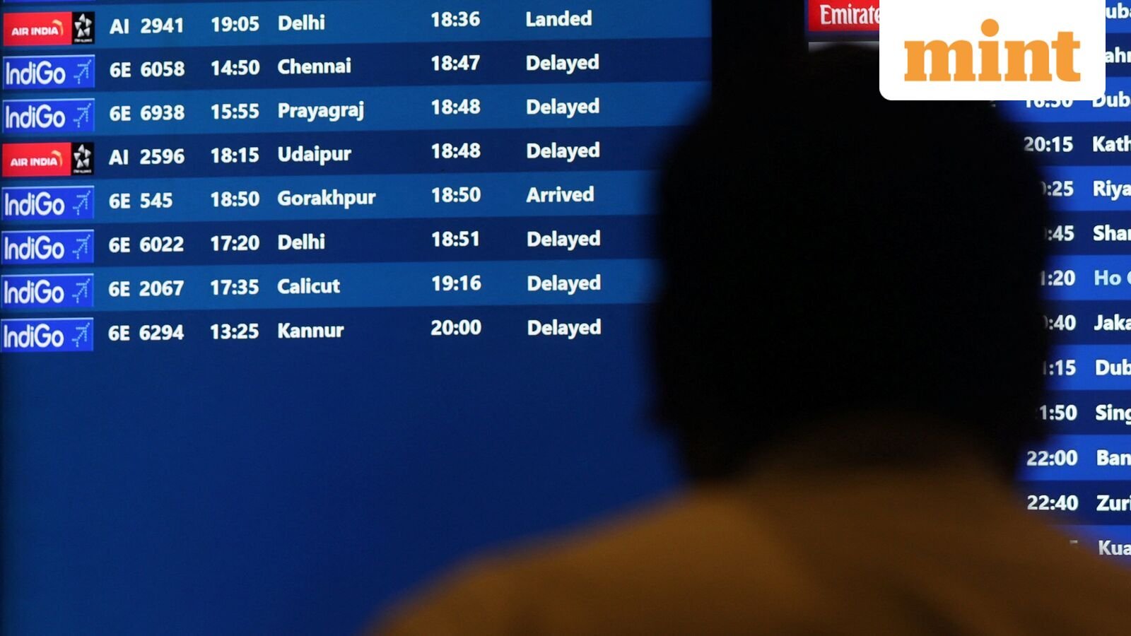 A man looks at a fight schedule screen displaying several delayed flights by IndiGo airlines at the Chhatrapati Shivaji Maharaj International Airport in Mumbai, India,